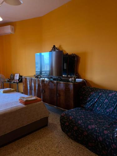 a living room with a couch and a large screen tv at Scalea City Center Apartments in Scalea