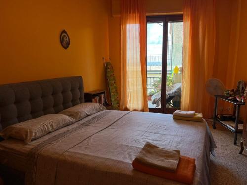 a bedroom with a large bed in a room with a window at Scalea City Center Apartments in Scalea