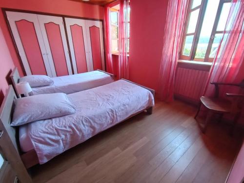 a bedroom with two beds and a table and windows at Gîte des Pierres Dorées in Saint-Germain-Nuelles