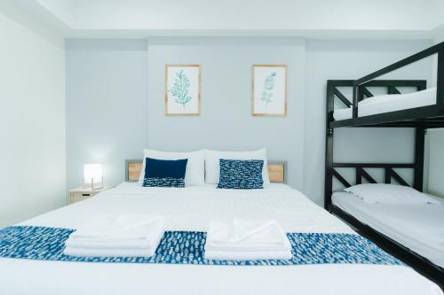 a bedroom with a large white bed with blue pillows at Annahouse in Chiang Rai