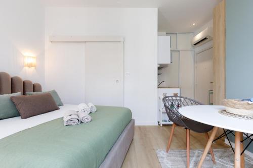 - une chambre avec un lit et une table avec des serviettes dans l'établissement Comfortable studio W balcony Cannes center TGV, à Cannes
