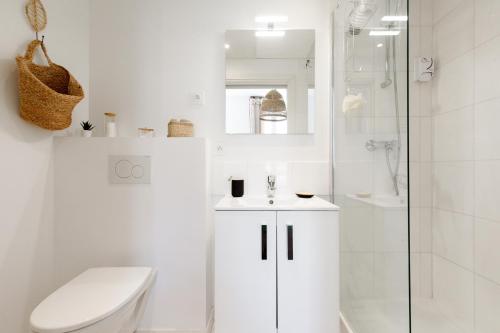 Un baño blanco con inodoro y ducha. en Comfortable studio W balcony Cannes center TGV, en Cannes