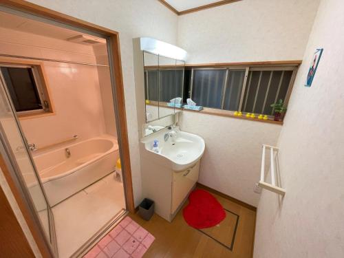 uma casa de banho com um lavatório, um espelho e um chuveiro em 大湖人家　田園風景を眺めなれる、ゆったりとしたゴージャスな屋敷 em Taga