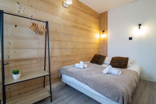 - une chambre avec un mur en bois et un lit dans l'établissement Etoile des neiges 2 min du centre, à Annecy