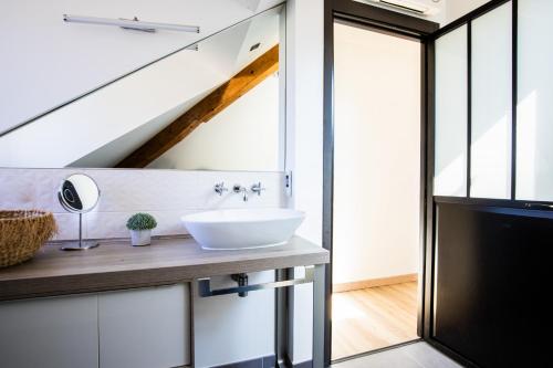 La salle de bains est pourvue d'un lavabo sur un comptoir à côté d'une fenêtre. dans l'établissement Duplex Albigny 3 minutes du lac, à Annecy