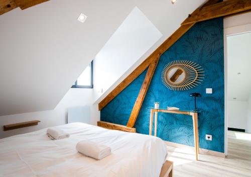 - une chambre avec un lit blanc et un mur bleu dans l'établissement Duplex Albigny 3 minutes du lac, à Annecy