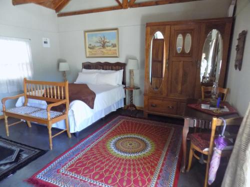 1 dormitorio con 1 cama, 1 silla y 1 mesa en Jaloersplek / Victorian On Vaal, en Parys