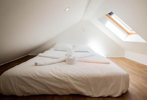 une chambre avec un lit blanc dans un grenier dans l'établissement Litchi lovely loft with AC rue du Paquier, à Annecy