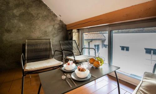 Cette chambre dispose d'une table, de chaises et d'un balcon. dans l'établissement Litchi lovely loft with AC rue du Paquier, à Annecy