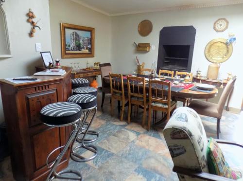 a living room with a table and chairs and a television at Jaloersplek Victorian On Vaal Main House in Parys