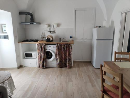 a kitchen with a white refrigerator and a washing machine at Casetta nel Centro Storico in Martina Franca