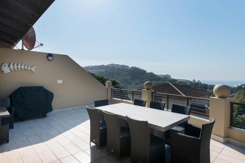 a patio with a table and chairs on a balcony at Bayridge 48 ~ Penthouse in Ballito