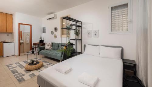 a bedroom with a white bed and a living room at Downtown Beach Apartment in Tel Aviv