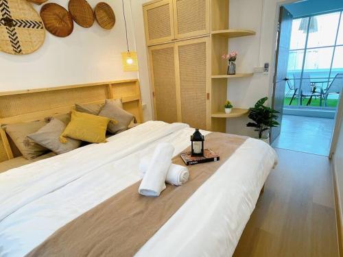 a large white bed with a bottle of wine on it at Relax Private terrace&cozy BR,near Grand palace in Bangkok