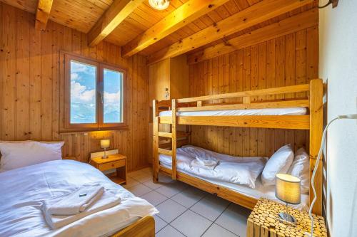 a bedroom with two bunk beds in a log cabin at Les 2 Sabots in Nendaz
