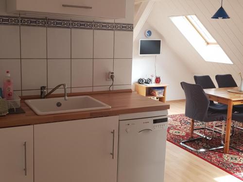 a kitchen with a sink and a table with chairs at Ferienwohnung Wolf in Nietwerder