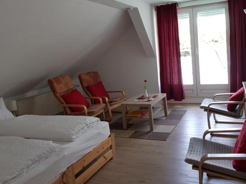 a bedroom with two chairs and a bed and a window at Ferienwohnung Wolf in Nietwerder