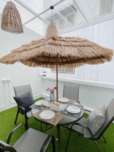 a table with chairs and a large umbrella at Relax Private terrace&cozy BR,near Grand palace in Bangkok