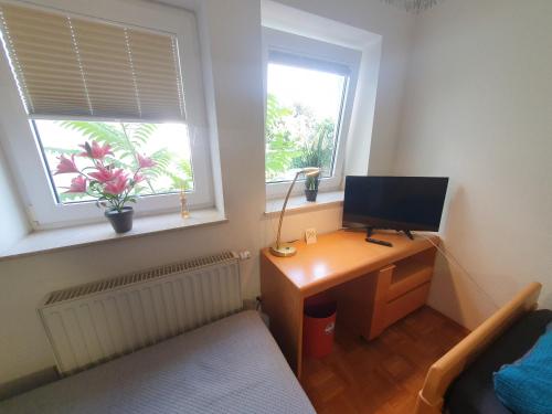 a bedroom with a desk with a computer and a window at ABM Apartment Haus in Zwingenberg