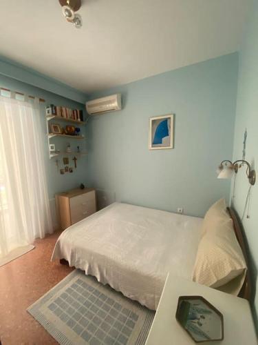 a bedroom with a bed and a table with a laptop at Anastasia's Seaview apartment in Hanioti