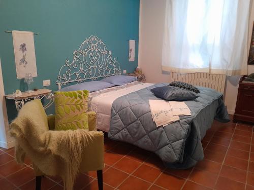 1 dormitorio con 1 cama y 1 silla en BLUVERDE, en Seregno