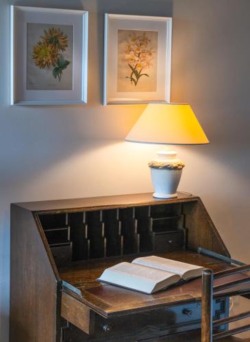 a lamp on a wooden desk with a book and a lamp at Casale1918 in Pietrasanta