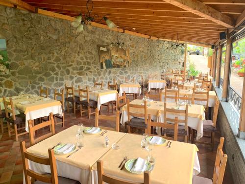 a restaurant with tables and chairs and a stone wall at La Favorita Apricale B&B & Ristorante in Apricale