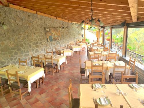 a restaurant with tables and chairs and a stone wall at La Favorita Apricale B&B & Ristorante in Apricale
