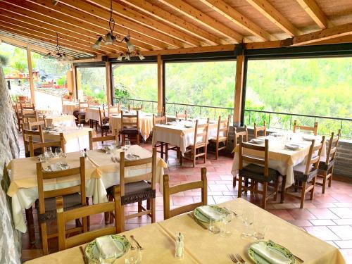 a dining room with tables and chairs and windows at La Favorita Apricale B&B & Ristorante in Apricale
