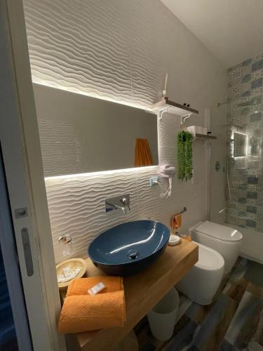 a bathroom with a blue sink and a toilet at Montebello Luxury Apartment in Peschici