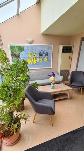 a lobby with a couch and chairs and plants at Mirana Family Hotel in Burgas City