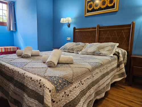 a bedroom with a bed with blue walls at Hotel Rural Casa Migio in Urbiés
