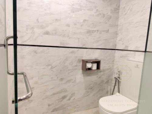a bathroom with a toilet and a glass shower stall at The Platinum 2 Kuala Lumpur by LUMA in Kuala Lumpur