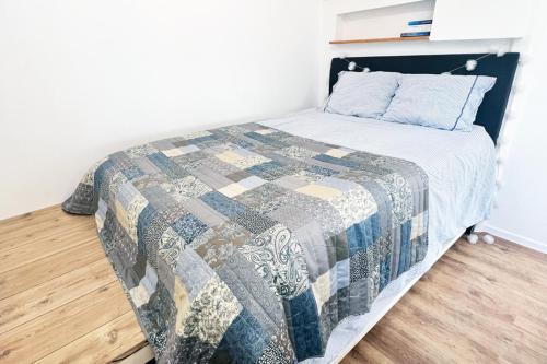 a bedroom with a bed with a quilt on it at Pebble Cottage•Yard•Parking•Wifi in Stockholm