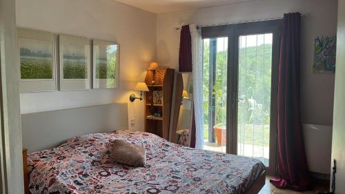 een slaapkamer met een bed en een groot raam bij val dazur valbonne Les Jasmins in Villeneuve-Loubet