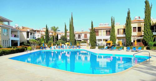 a large pool with blue water in a resort at Anthea Gardens - Cosy Condo in Paphos City