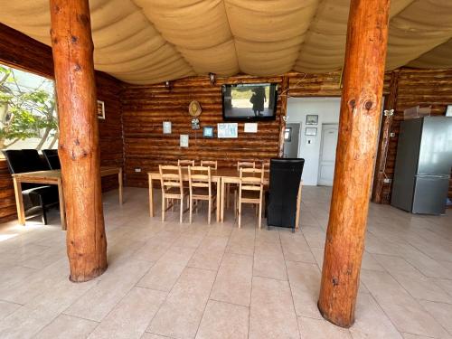 a dining room with a table and chairs and a television at Casa Analys in Douăzeci şi Trei August