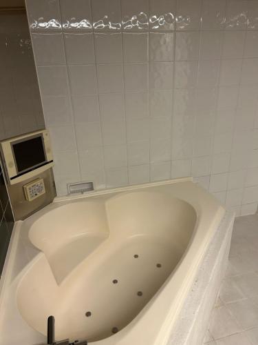 a large white bath tub in a bathroom at 本庄バニラリゾート in Ishigami