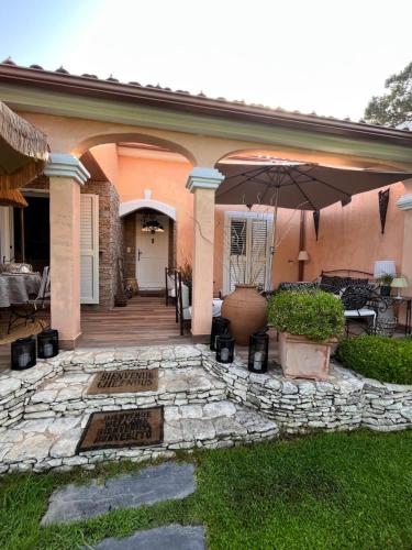 a house with an umbrella and a patio at Chez Virginie in Porto-Vecchio