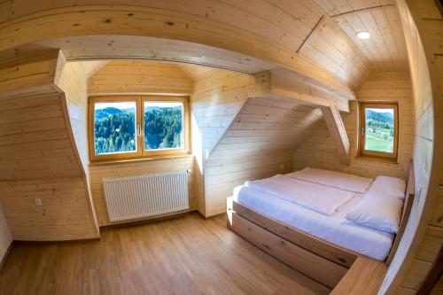 ein kleines Schlafzimmer mit einem Bett in der Mitte in der Unterkunft Apartmaji na kozolcu - Smogavc in Zreče