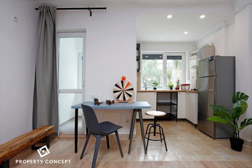 una pequeña cocina con mesa azul y sillas en Avangarde Concept Studio, en Roşu