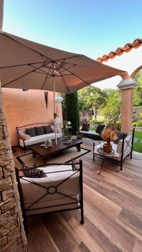 a patio with a table and an umbrella at Chez Virginie in Porto-Vecchio