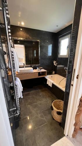 a bathroom with a tub and a sink and a bath tub at Chez Virginie in Porto-Vecchio