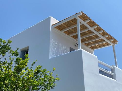 a window on the side of a white building with trees at Zeus Suite in Triovasálos