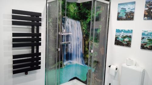 a bathroom with a shower with a waterfall mural at Ferienhaus Bea in Buchholz Aller