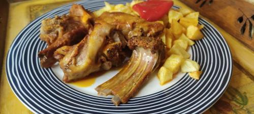 a plate of food with meat and french fries at Hotel Rural Casa Migio in Urbiés