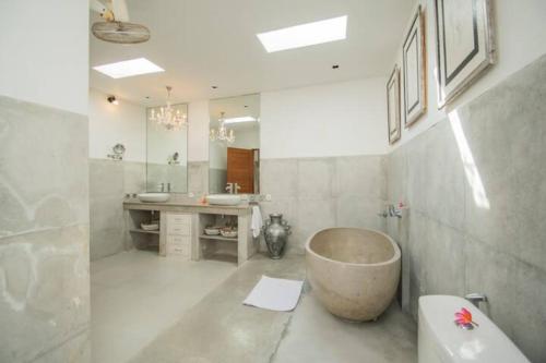 a bathroom with a large tub and a sink at Villa Shanti in Seminyak
