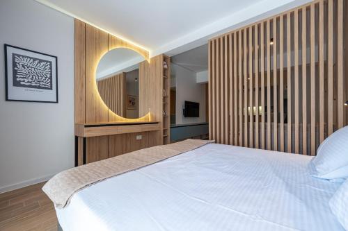 a bedroom with a large bed and a round mirror at Bonita Residence in Dobrota