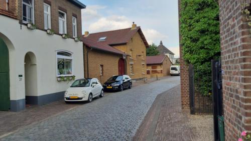 dwa samochody zaparkowane na ulicy obok budynków w obiekcie Boerderijwoning Elsloo w mieście Elsloo