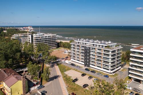 an aerial view of a city with buildings and the ocean at Solaris Darłówko Premium Emilia Strupiechowska in Darłowo